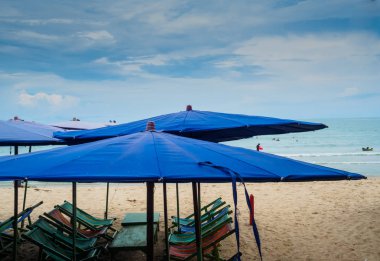 Plaj şezlong ve plaj şemsiyeleri güneşli bir günde, mavi 