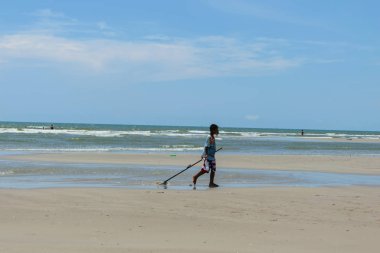 Hua Hin, Prachuabkirikhan, Tayland 17 Nisan 2017: kumsalda genç balıkçı tarak kullanarak ekskavatörler.