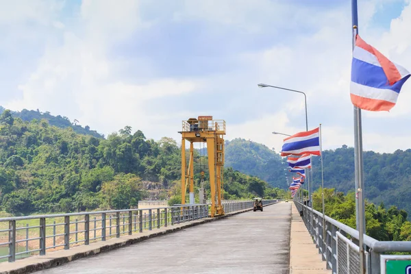 Perspective view of a long road dam, with golf car and Thai national  flags. — Stock Photo, Image