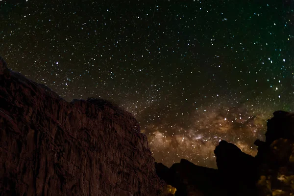 Via Láctea e um monte de estrelas sobre a montanha em Wadi Rum deser — Fotografia de Stock