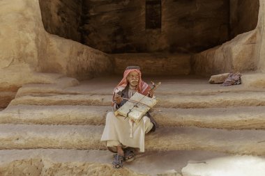 Küçük Petra, Ürdün - 20 Haziran 2017: Eski Bedevi adam ya da küçük Petra kapı onun müzik aleti çalma Arap adam geleneksel kıyafeti,. 