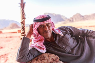Wadi Rum, Ürdün - 20 Haziran 2017: Bedevi adam veya çöl arka koltuğa uzanmış Arap adam geleneksel kıyafeti,.