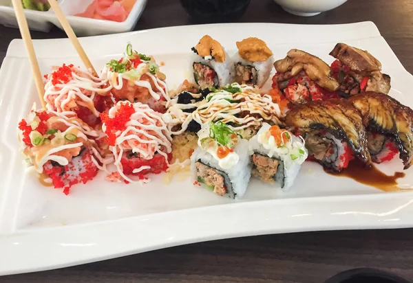Смешанные суши, японская еда, расположенная в белой тарелке . — стоковое фото
