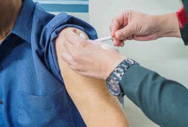 Hastanın hastanede bir aşı almak yakın. Enjeksiyon hastalar üst kol steril ekipmanları ile bir hemşire tarafından tedavi edilir.