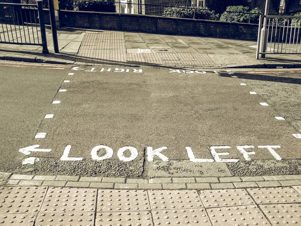 Vintage tittar ser rätt utseende vänster skylt på London zebra crossi — Stockfoto