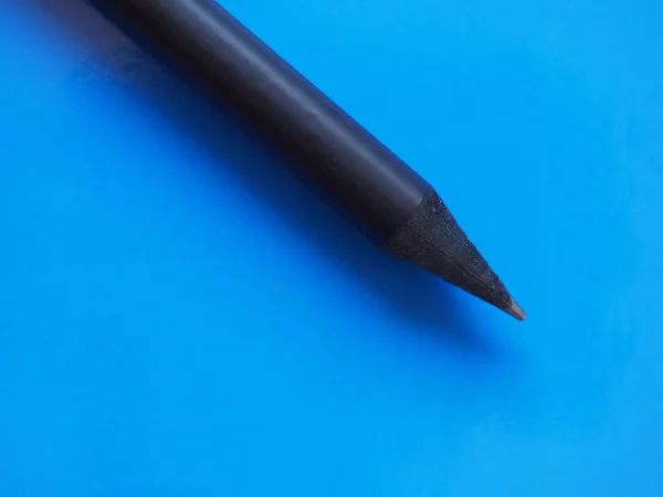 Černá tužka nad modrý s copy prostor — Stock fotografie