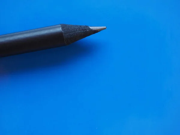 Black pencil over blue with copy space — Stock Photo, Image