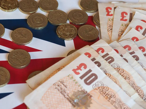 Monedas y billetes de Libra, Reino Unido sobre bandera —  Fotos de Stock