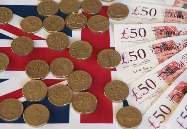 Moedas e notas de libra, Reino Unido sobre a bandeira — Fotografia de Stock