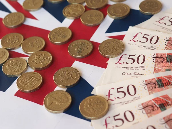 Pièces et billets en livre sterling, Royaume-Uni sur drapeau — Photo