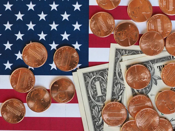 Долларовые банкноты, монеты и флаг США — стоковое фото