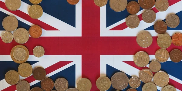 Libra monedas, Reino Unido sobre bandera —  Fotos de Stock