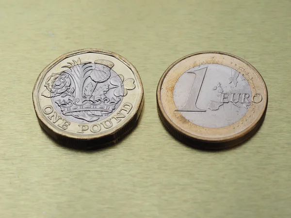 1 pund och 1 euro mynt över metall bakgrund — Stockfoto