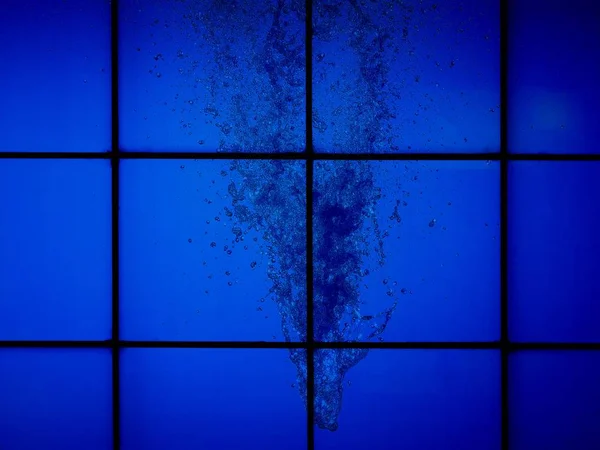 Брызги воды за стеклянной стеной — стоковое фото