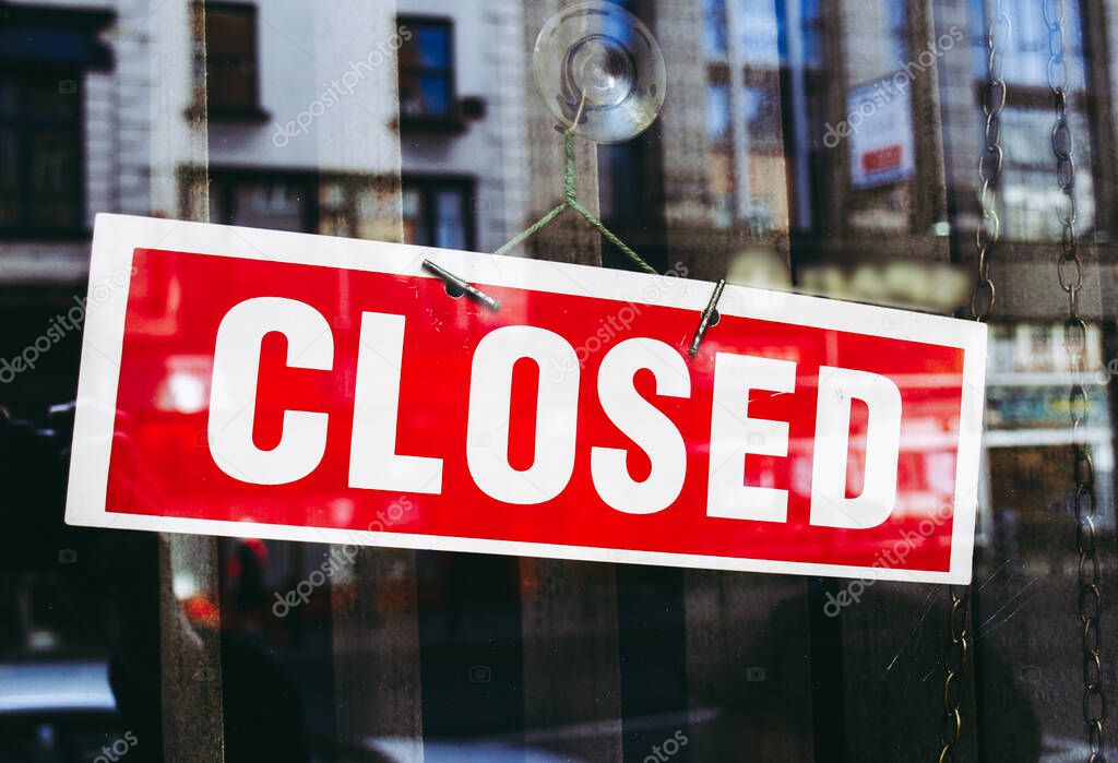 Closed sign in a shop window with reflections