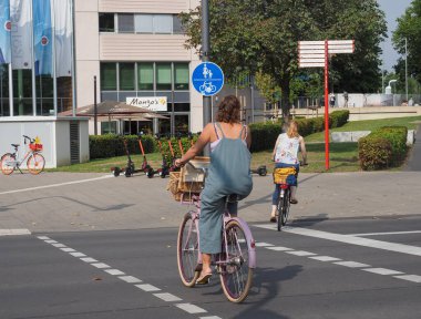 KOELN, GERMANY - CIRCA AĞUSTOS 2019: Şehir merkezinde bisiklet süren kadın