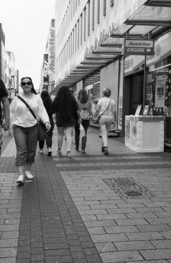 KOELN, GERMANY - CIRCA AUGust 2019: Hohe Caddesi 'ndeki insanlar (anlamı High Street) siyah beyaz alışveriş caddesi