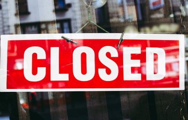 Yansımaları olan bir dükkan penceresinde kapalı tabela