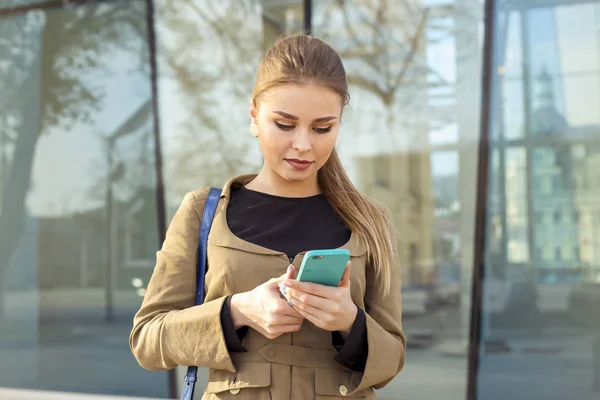 Jonge vrouw schrijven sms op werk. — Stockfoto