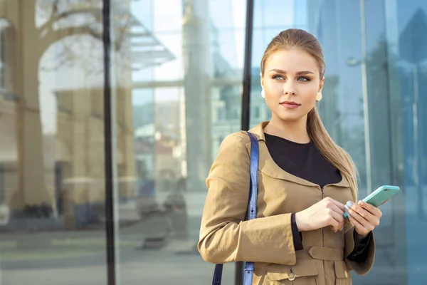 Aantrekkelijke blonde meisje met blauwe ogen. meisje houdt van een mobiele telefoon — Stockfoto