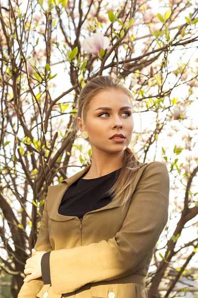 Blonde walks våren blommande trädgård — Stockfoto