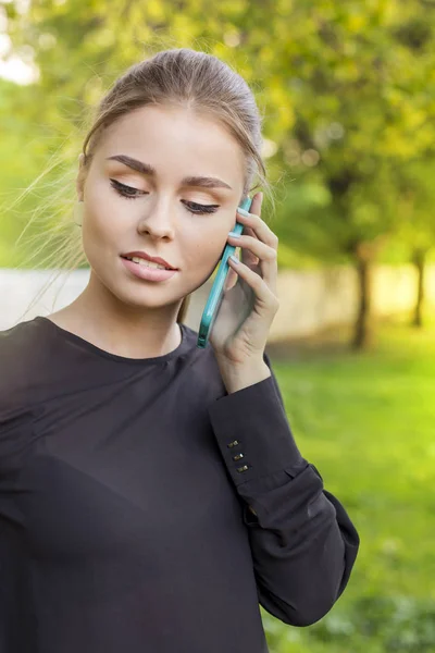 Portrait of a serious beautiful woman talking on the phone on street — Stock Photo, Image