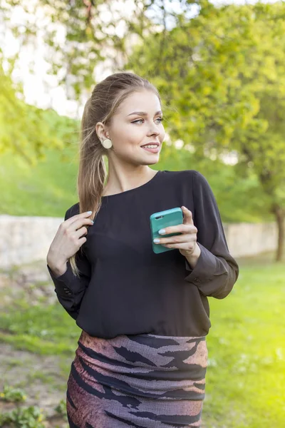 Portrait of a smiling beautiful woman texting with her phone — Stock Photo, Image