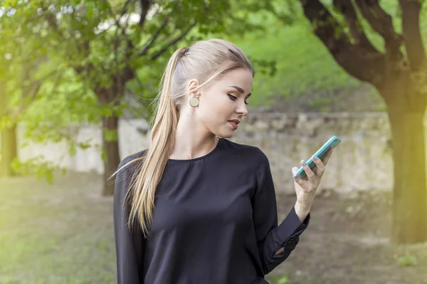 Attractive blond woman talking on a cell phone on the street. important call — Stock Photo, Image
