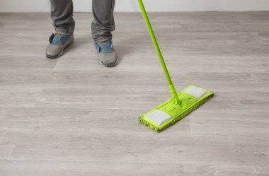 Ev işleri ve temizlik kavramı. ? kadar adam ayakları yere evde temizlik paspas ile kaybetmek