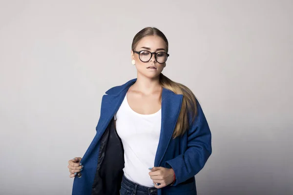 Loira na moda em um casaco azul escuro no estúdio — Fotografia de Stock