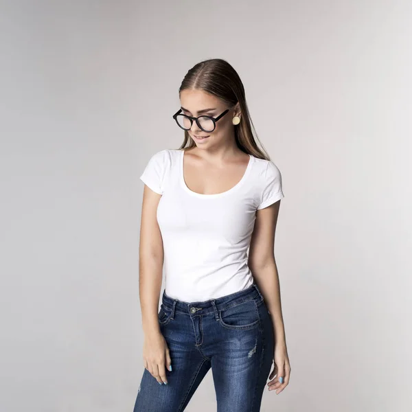 Krásná mladá dívka, která nosí bílé prázdné tričko a džíny — Stock fotografie