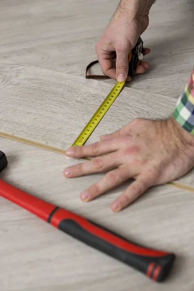 Homem instalando novo piso de madeira laminado — Fotografia de Stock