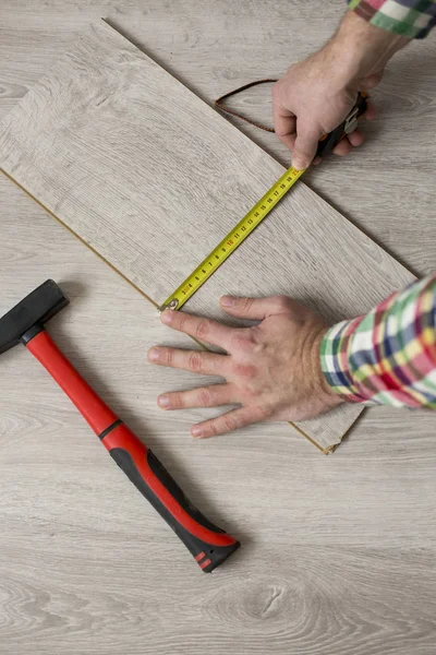 Homem que estabelece piso laminado no conceito de construção — Fotografia de Stock