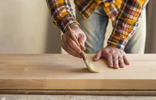 Man gets a special wax on wooden surface