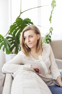 Güzel sarışın koltukta oturuyor ve pencereden görünüyor