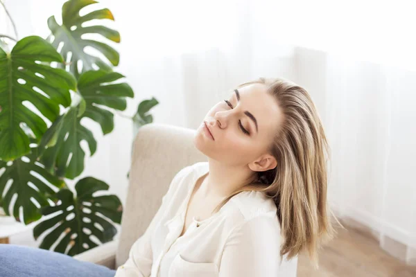Profilo di una bella donna che si rilassa sdraiata su un divano a casa — Foto Stock