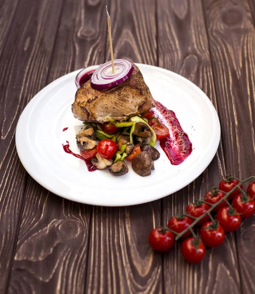 Saftige Portionen gegrilltes Filetsteak serviert mit Tomaten und gebratenem Gemüse auf altem Holztisch — Stockfoto