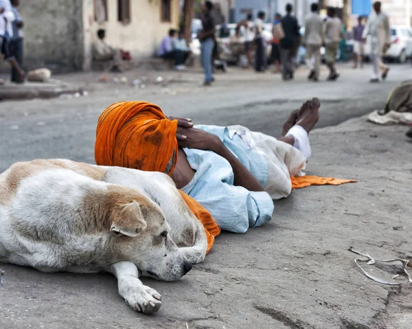 Pobre hombre durmiendo en un camino divisor en Nueva Delhi, India Imágenes De Stock Sin Royalties Gratis