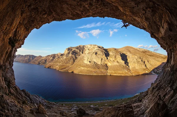 Rock climber climbing along cave — Stockfoto