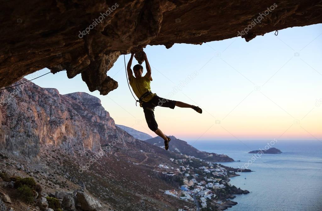 Rock climber jumping on handholds