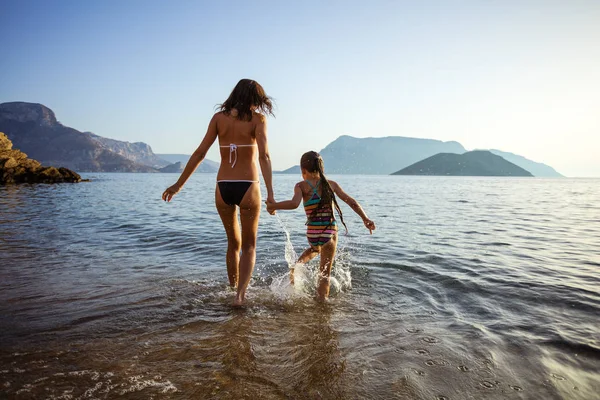Mulher e sua filha andando no mar — Fotografia de Stock