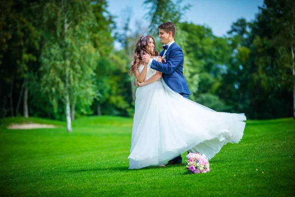 Beautiful young bride and groom in park — Stock Photo, Image