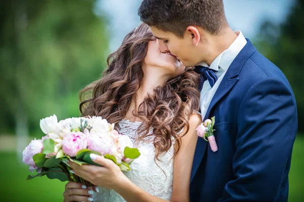 Bride and groom kissing in park — Stock Photo, Image