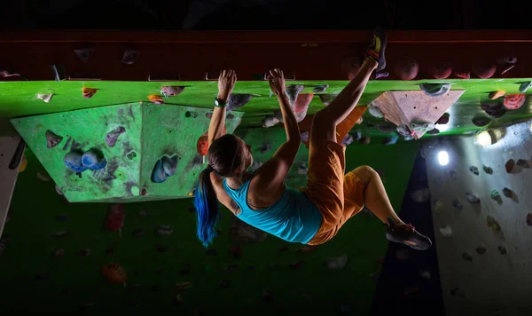Jeune femme bloc le long du plafond de la salle de gym d'escalade intérieure — Photo