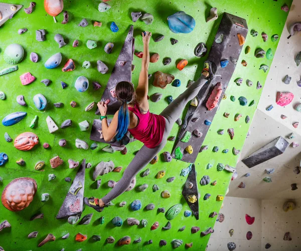 Young woman bouldering on climbing gym — Stock Photo, Image