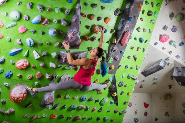 Young woman bouldering on climbing gym — Stock Photo, Image