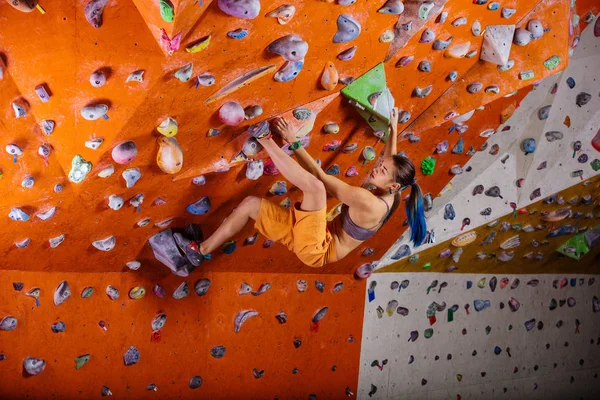 Frau beim Bouldern in Kletterhalle — Stockfoto