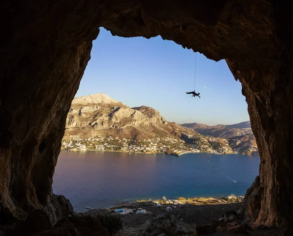 Giovane arrampicata lungo le rocce — Foto Stock