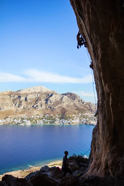 Jeune homme grimpant le long des rochers — Photo