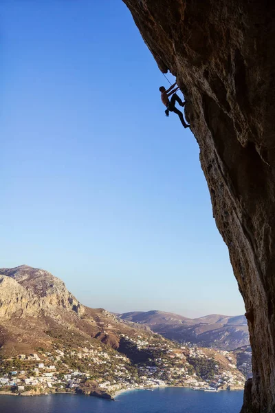 Junger Mann klettert an Felsen entlang — Stockfoto